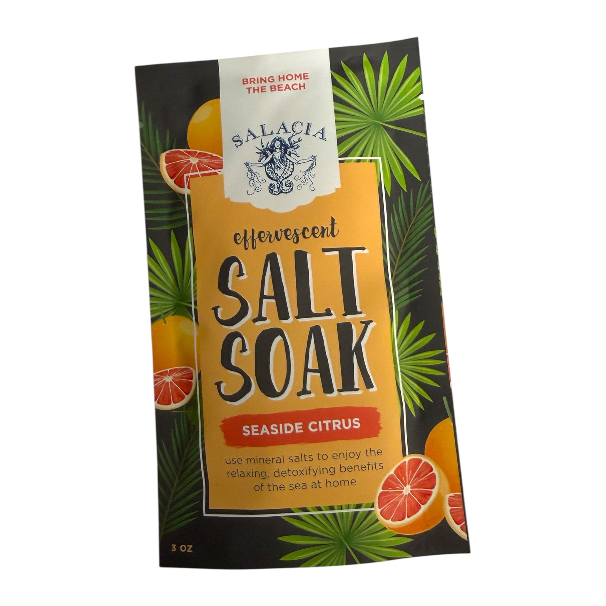 A 3 oz pouch of Salacia Effervescent Salt Soak in Seaside Citrus flavor, featuring a tropical design with green palm leaves, orange slices, and a yellow-orange central label on a black background.